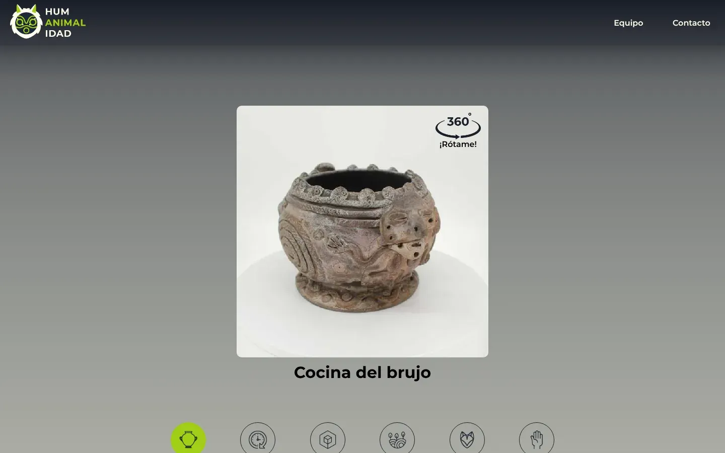 Una página de pieza de Humanimalidad en escritorio: un encabezado oscuro con el logo del búho HUM ANIMAL IDAD y luego un visor cuadrado que muestra una vasija de cerámica gris cubierta de espirales y pequeñas cabezas de serpiente, girada de modo que a la derecha se ve un rostro humano modelado en su costado. Una insignia 360° ¡Rótame! está en la esquina, debajo aparece el título Cocina del brujo y abajo empieza una fila de pestañas redondas con íconos.